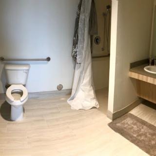 A clean and minimalistic bathroom featuring a toilet, shower area, and sink.