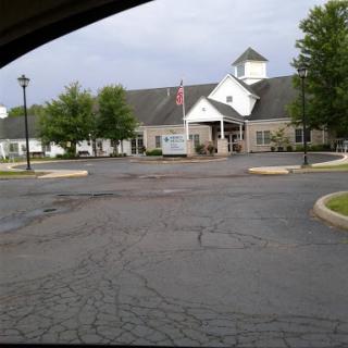A view of a building from a parking lot under a cloudy sky.