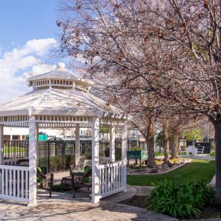 A charming gazebo surrounded by blooming trees in a tranquil garden setting.