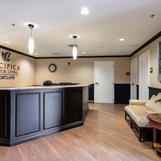 A modern reception area with elegant interior design, featuring a black desk and comfortable seating.
