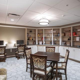 A modern library room with tables, computers, and bookshelves.