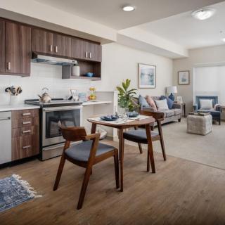 A modern and cozy open-plan apartment featuring a kitchen, dining area, and living room.