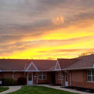 A beautiful sunset illuminating the sky behind cozy brick homes.