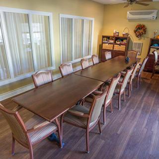 A spacious conference room with a long meeting table surrounded by several chairs.