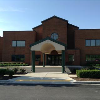 A modern brick building with a welcoming entrance and well-kept landscaping.