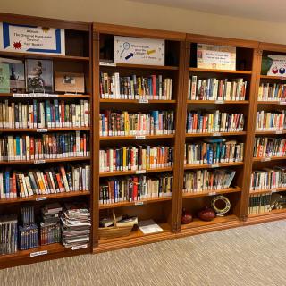 A neatly organized bookshelf filled with a variety of books in a library setting.