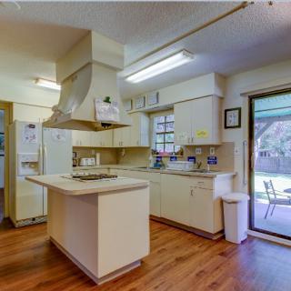 A modern kitchen with an island counter and wooden flooring.