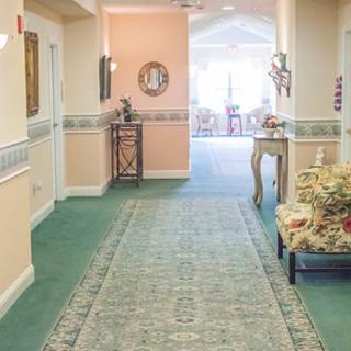 A well-decorated hallway with a green carpet and elegant furnishings.