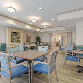 A well-lit dining area with neatly arranged tables and chairs.