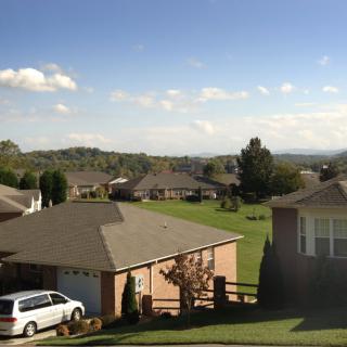 A peaceful suburban neighborhood under a clear blue sky.
