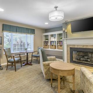 A cozy living room with a fireplace, comfortable seating, and a television.