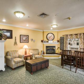 A cozy living room with a sofa and dining area, featuring a fireplace and warm decor.