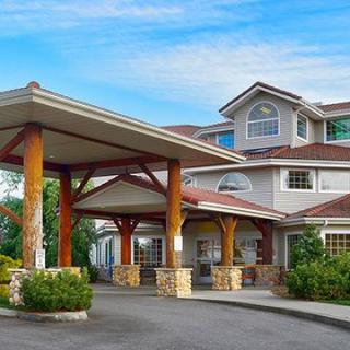 A large, multi-story building with a covered entrance and rustic wooden pillars.