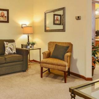 Cozy living room with a sofa, chair, and warm lighting.