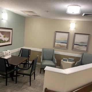 A cozy waiting area with a table, chairs, and wall artwork.
