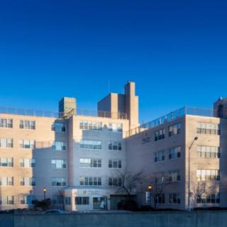 A multi-story building under a clear blue sky, possibly a hospital or residential complex.