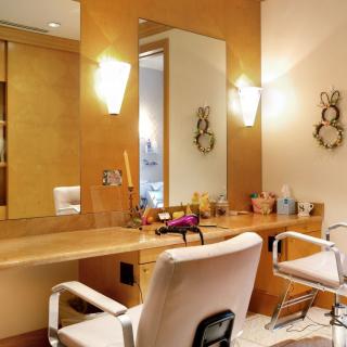 A stylish hair salon interior with comfortable chairs and a well-lit vanity area.