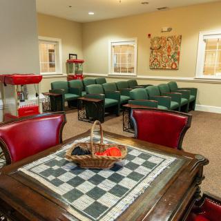 A cozy lounge with a chess table and popcorn machine, perfect for relaxation.