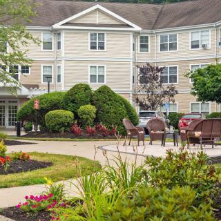 A well-maintained residential building with a landscaped garden and outdoor seating area.