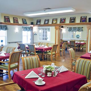 A cozy dining room with neatly set tables and comfortable chairs.