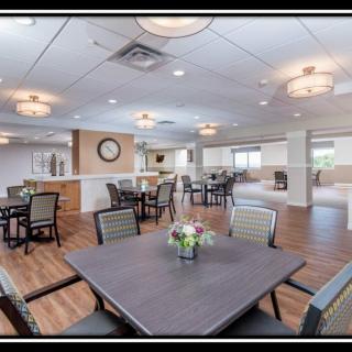 A modern dining area featuring several tables and chairs, with stylish lighting and interior decor.
