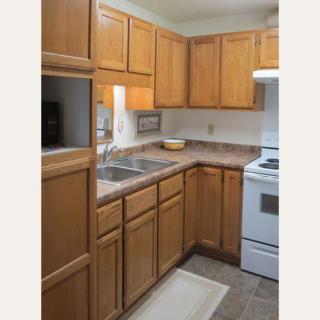 Compact kitchen with wooden cabinets and appliances.