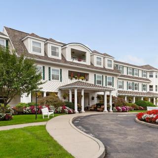A large residential building with landscaped gardens and a driveway.