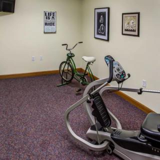 A small exercise room with fitness equipment including a stationary bike and exercise machine.