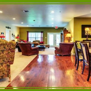 A spacious and warmly decorated living room with cozy seating and hardwood floors.