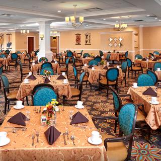 A spacious dining area set with tables and chairs, ready for guests.