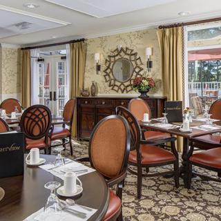 An elegant dining room with neatly arranged tables and chairs, featuring classic interior decor.
