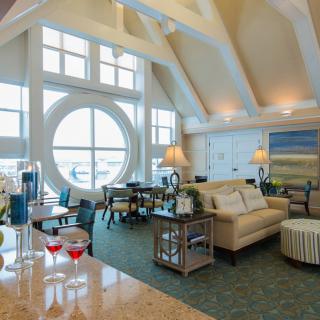 A luxurious living room with modern decor, featuring high ceilings and large windows.