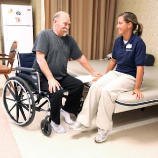 A nurse interacts with a patient in a medical facility, providing support and care.