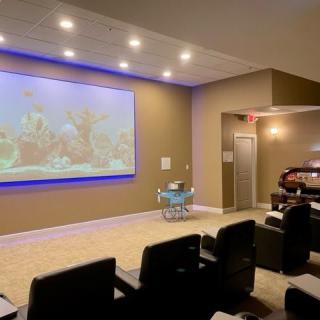 A cozy home theater setup with a large projector screen and comfortable seating.