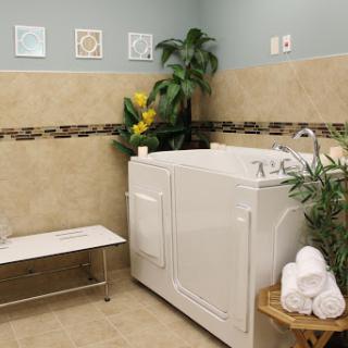 A serene spa bathroom featuring a whirlpool, towels, and plants for a relaxing atmosphere.