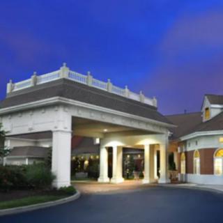 The entrance to a well-lit hotel building during the evening.