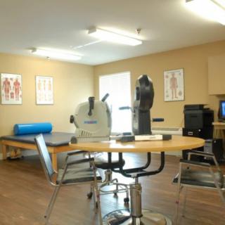 A physical therapy room equipped with exercise machines and treatment tables.