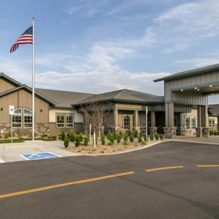 A modern building with an American flag and a parking lot featuring handicap spaces.