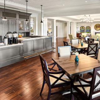 A spacious kitchen and dining area featuring hardwood floors, modern lighting, and stylish furniture.