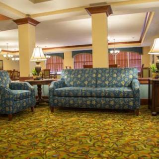A cozy hotel lobby featuring patterned furniture and warm lighting.