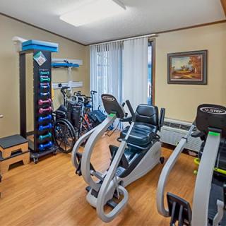 A small home gym with various exercise equipment, including bicycles and weights.