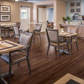 A cozy dining area with neatly arranged tables and chairs on a wooden floor.