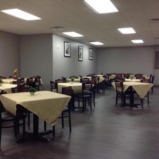 An empty restaurant dining area with tables and chairs neatly arranged.