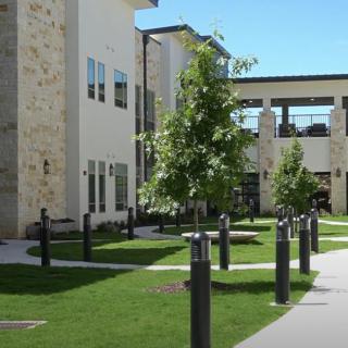 Modern building with landscaped outdoor area and pathway.