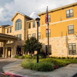 A modern residential building with a welcoming entrance and neatly landscaped surroundings.