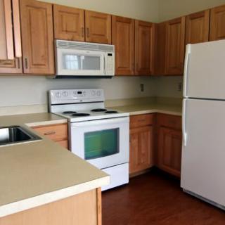 A modern kitchen with wooden cabinets and standard appliances.