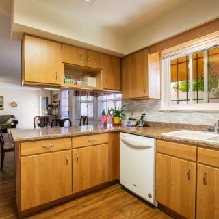 A cozy kitchen with wooden cabinets and a view of the dining area.