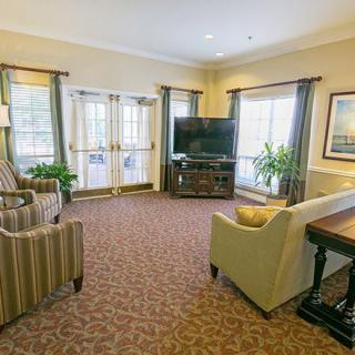 A cozy living room with comfortable seating, a large television, and plenty of natural light.