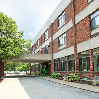 A modern brick building featuring a welcoming entrance and landscaped surroundings.