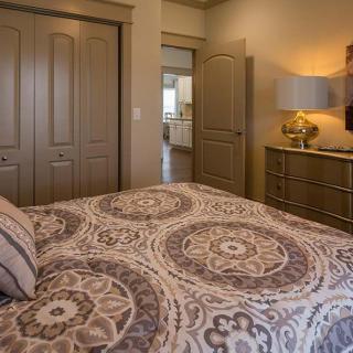 A cozy bedroom with patterned bedding and warm lighting.